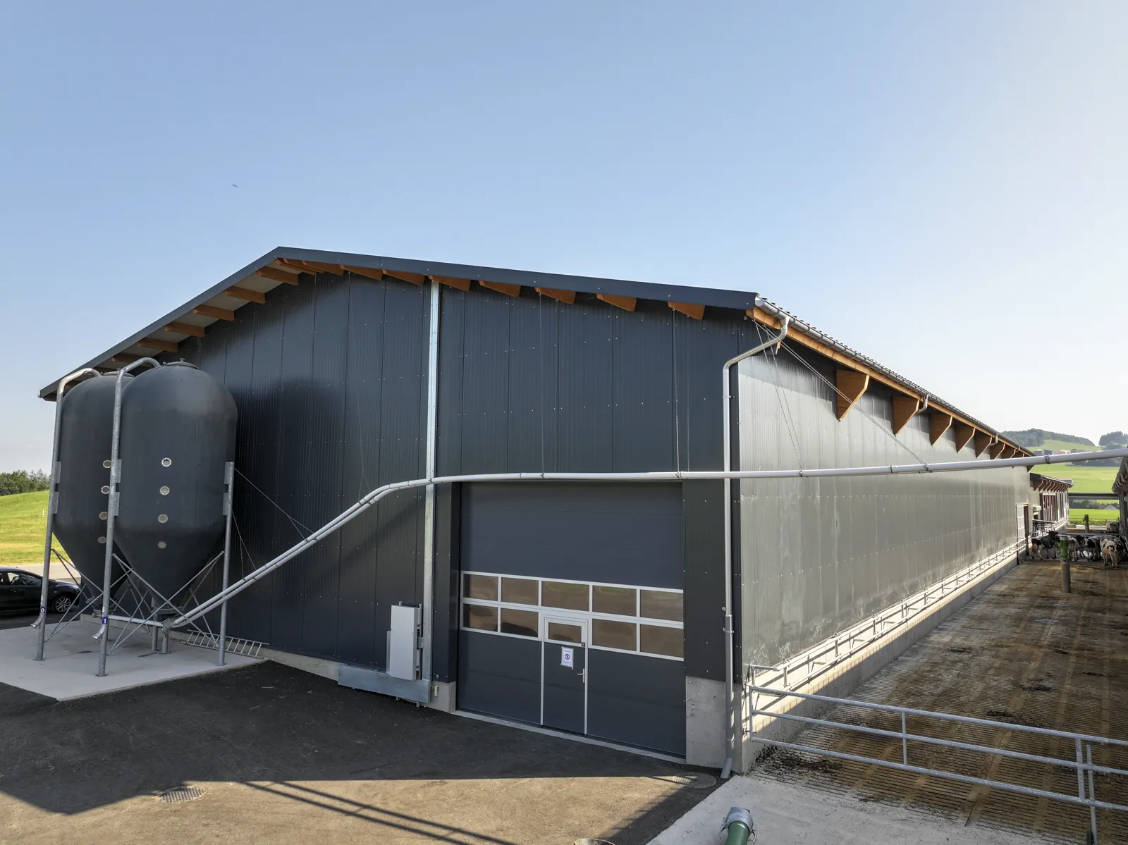 Vue extérieure d'un bâtiment de stabulation avec silo d'alimentation